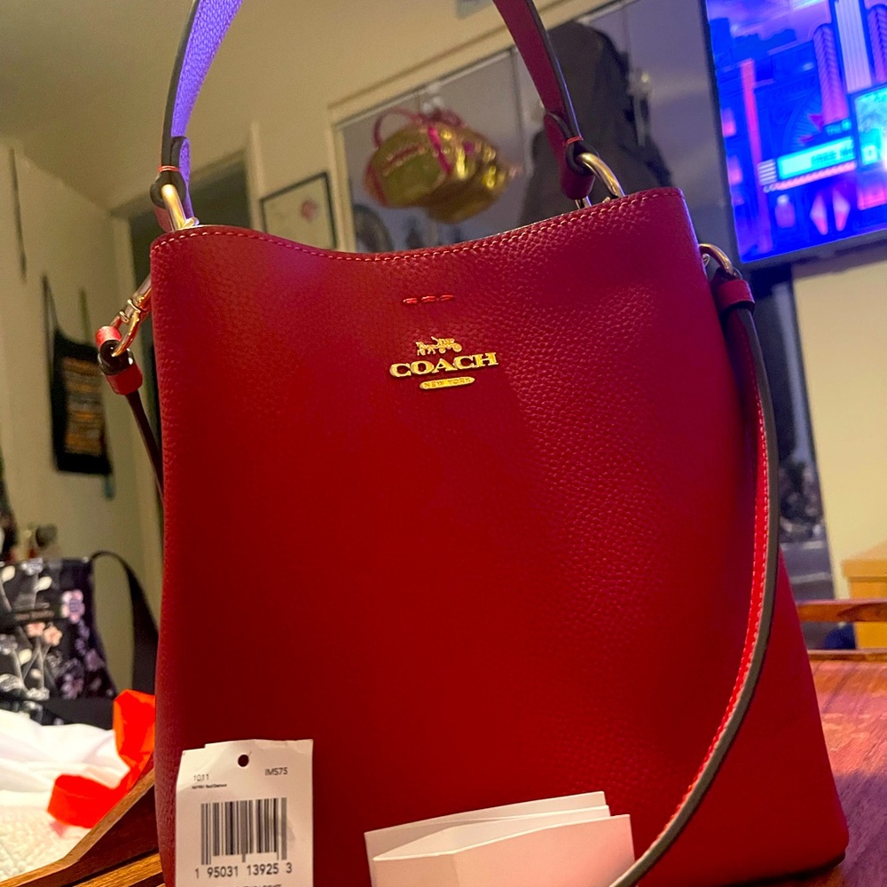 A new with the tags next to it ran coach Crossbody also with a handle bucket bag